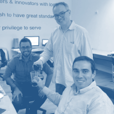 Photograph of Jules Bowden celebrating with coworkers overlaid with a light blue filter